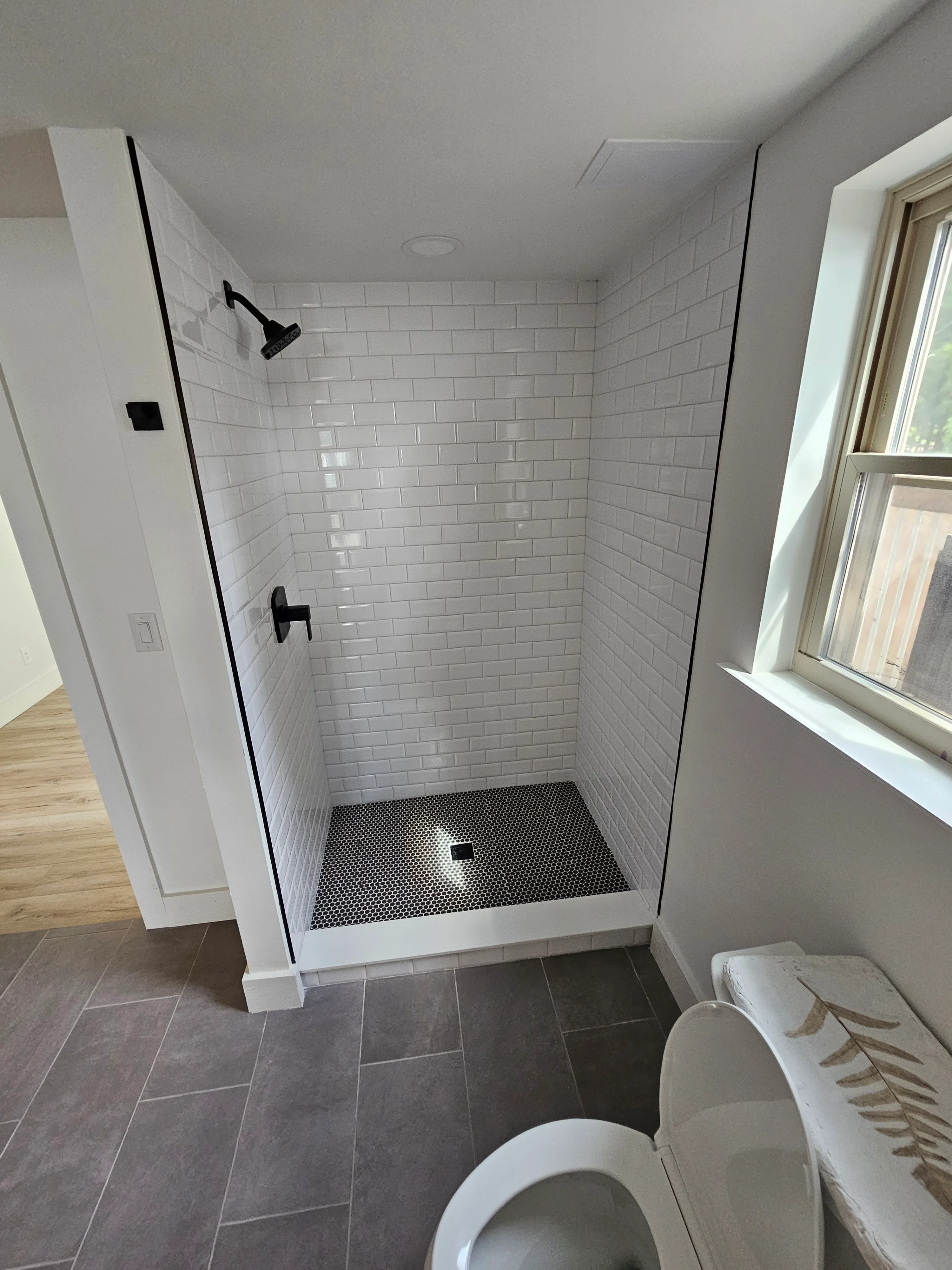 Shower with frameless glass and hexagonal tile completed by Triple R Construction Inc.