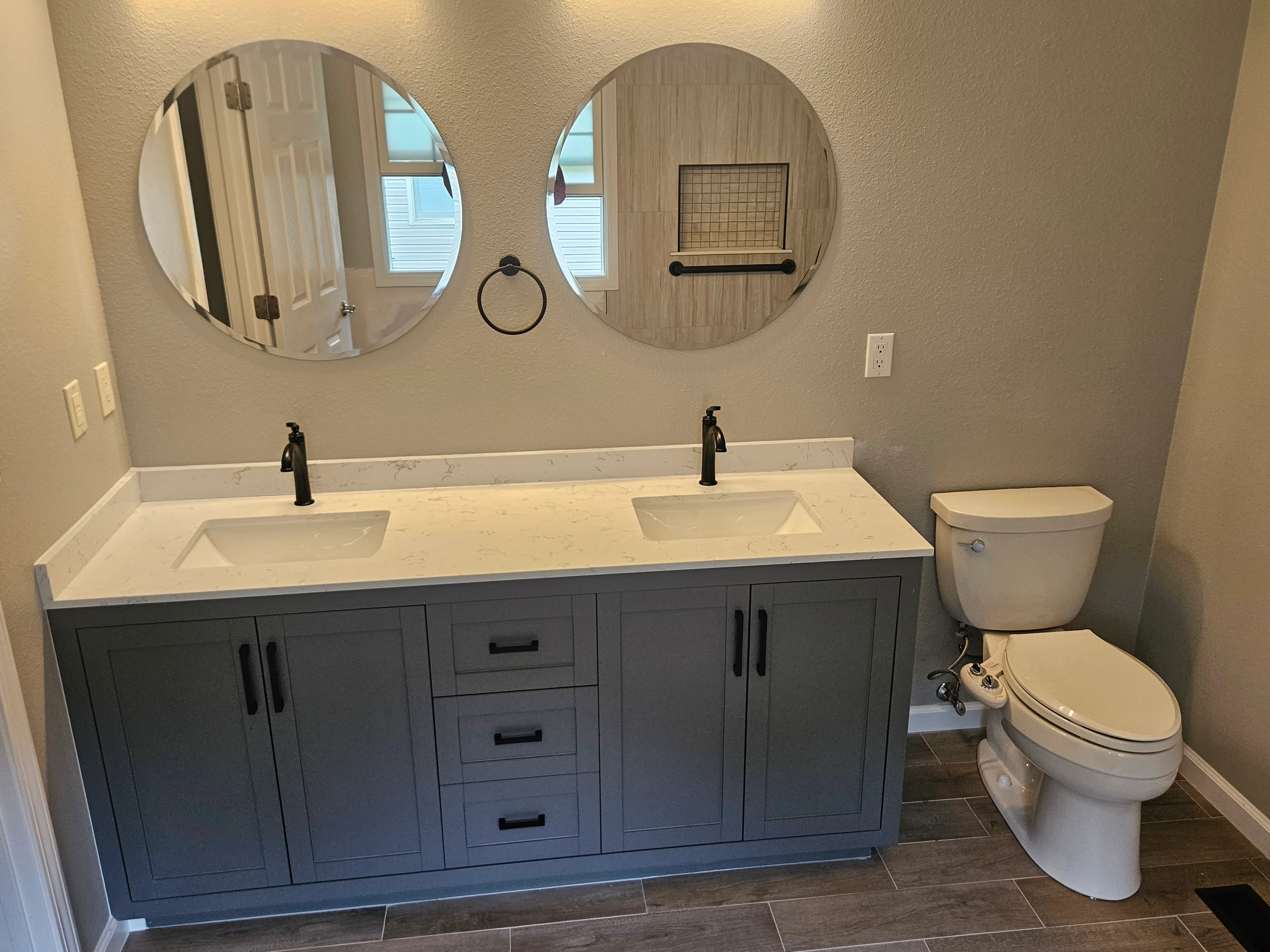 Bathroom with dark vanity and quartz top completed by Triple R Construction Inc.