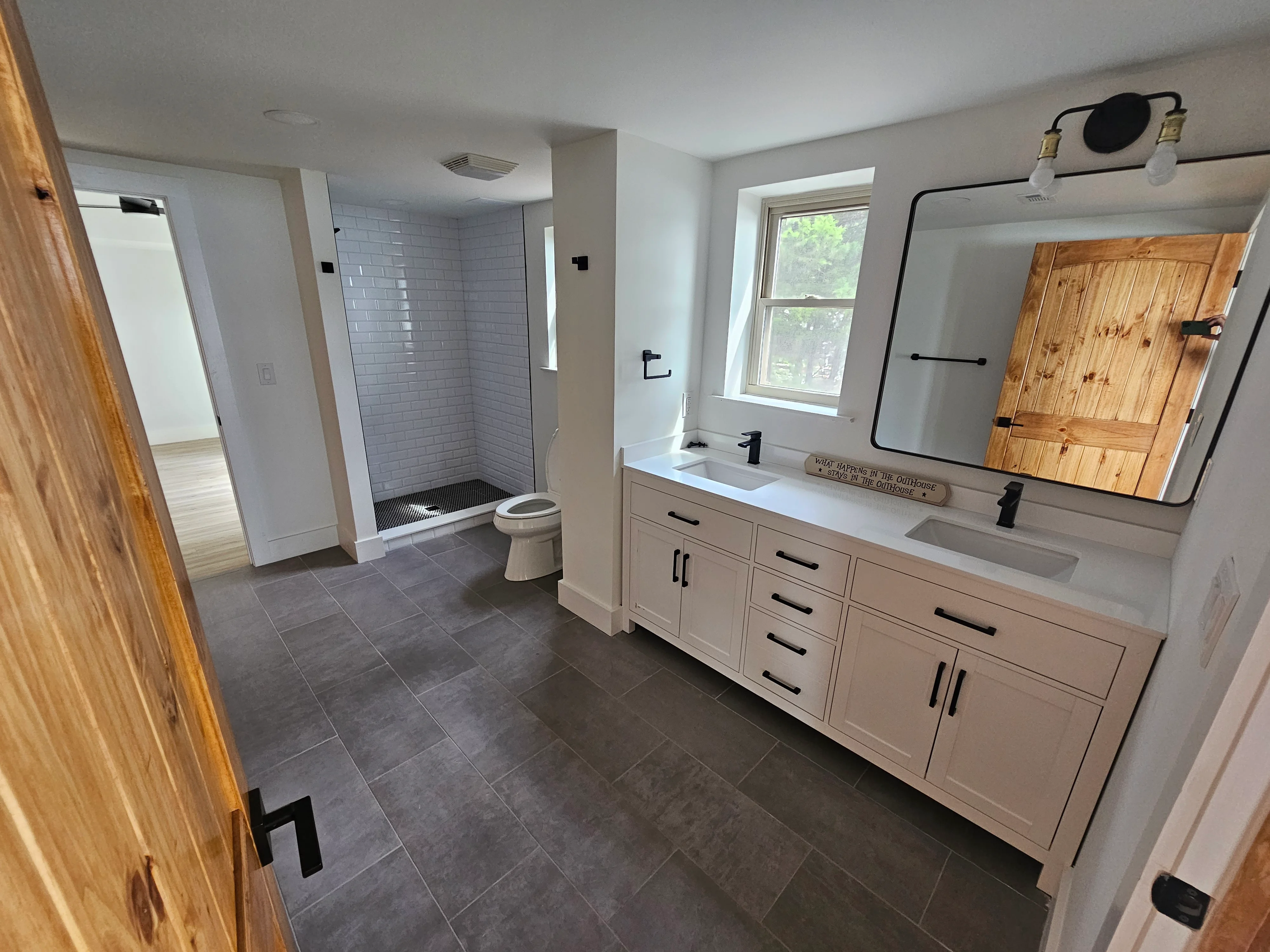 Master bathroom with white cabinets and slate floor completed by Triple R Construction Inc.